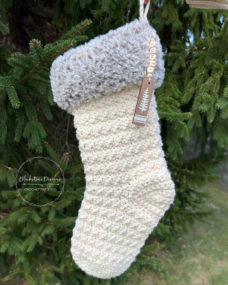 a knitted christmas stocking hanging from a tree