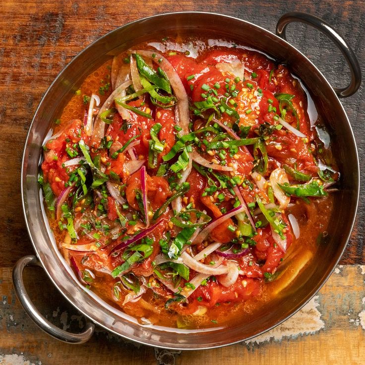 a pan filled with lots of food on top of a wooden table