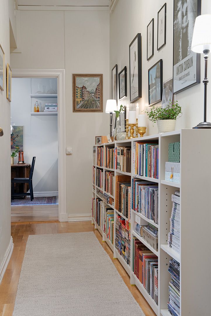 a room with bookshelves and pictures on the wall next to an open door