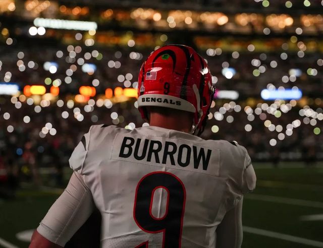 a football player wearing a red and white uniform looking out into the stadium at night