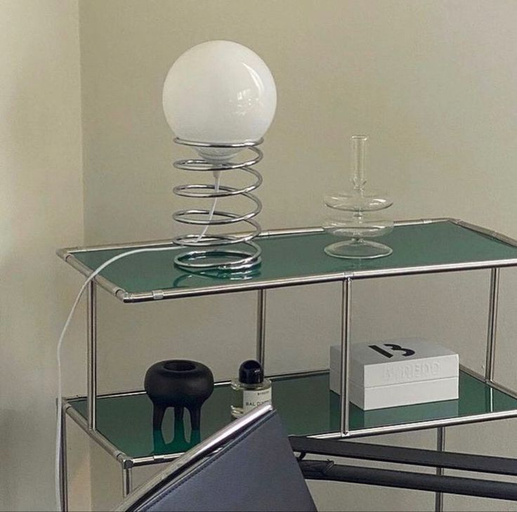 a glass shelf with a white ball on top and some other items sitting on it