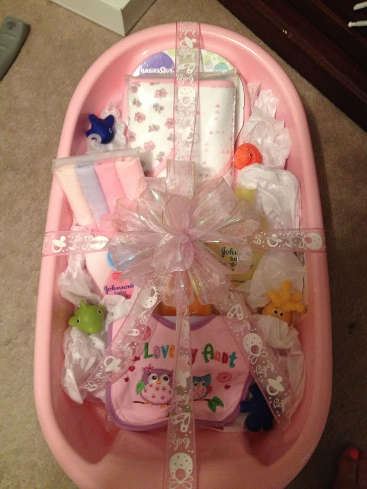 a pink baby bath tub filled with lots of toys