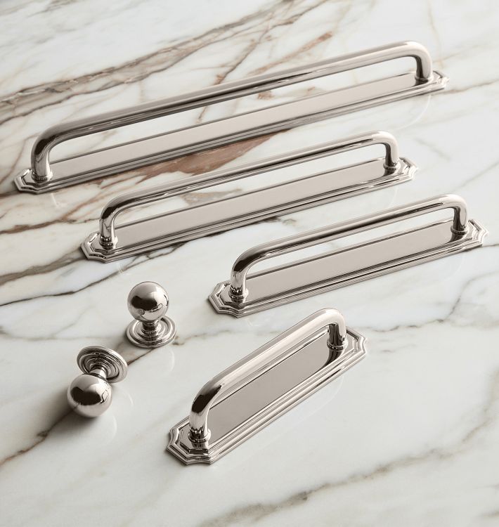 three chrome handles and two pulls on a marble counter