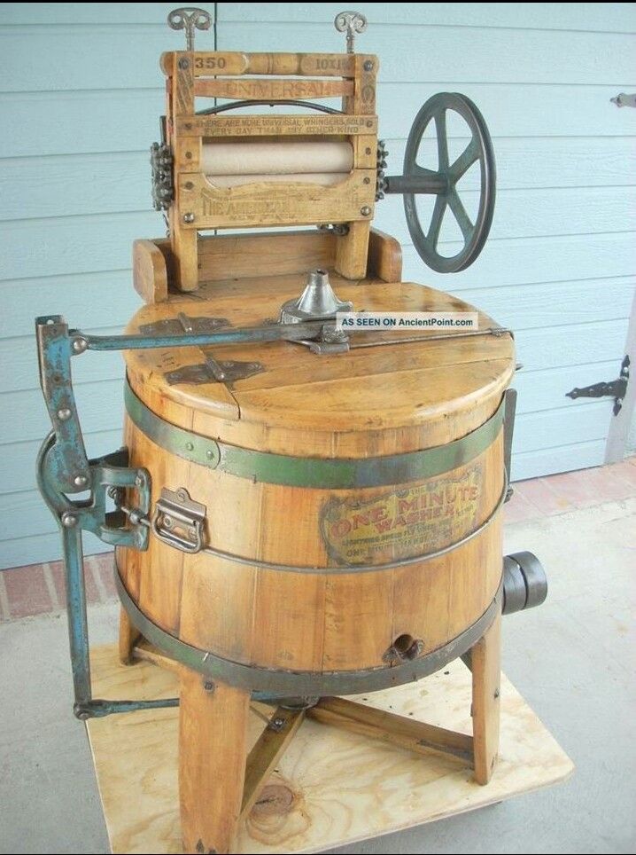 an old fashioned wooden barrel sitting on top of a piece of plywood and metal