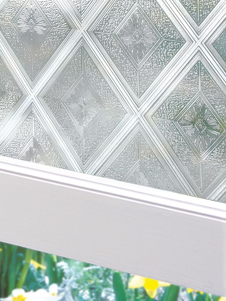 a close up of a glass window with flowers in the foreground and yellow daffodils in the background