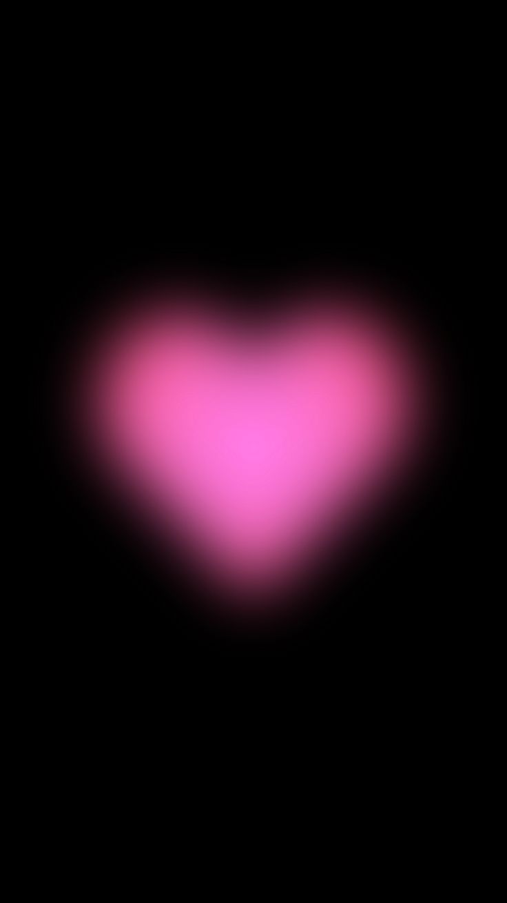 a blurry image of a pink heart in the dark