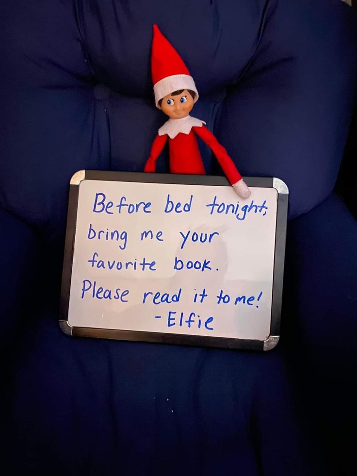 an elf is sitting in a chair holding a sign that says before bed tonight bring me your favorite book please read it to me