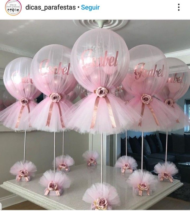 pink tutu ballons with bows and ribbons are arranged on a table in front of a mirror