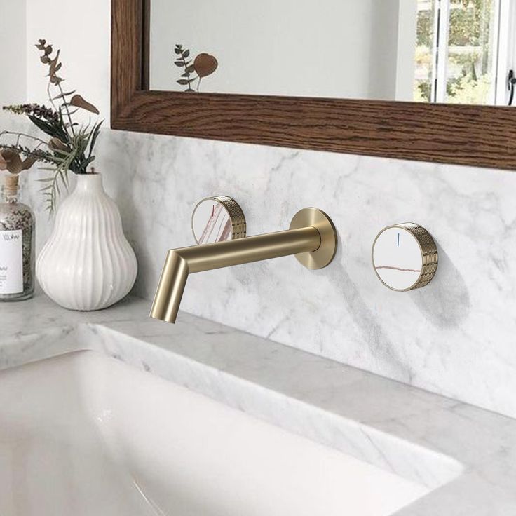 a bathroom sink with two faucets on the side and a mirror above it