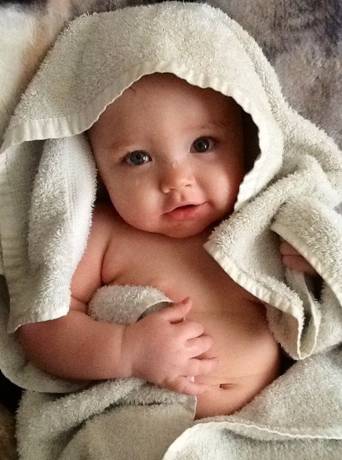 a baby wrapped in a towel on top of a bed