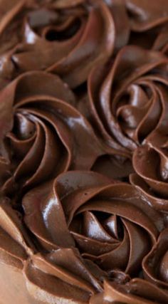 a close up view of chocolate frosting on top of a cake with swirls