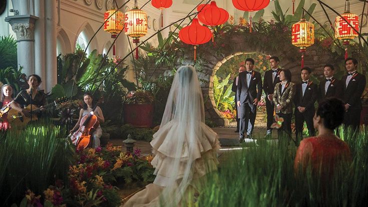 a bride and groom standing in front of an arch decorated with red lanterns at their wedding ceremony