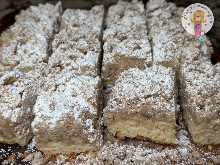 several pieces of cake sitting on top of a wooden tray covered in powdered sugar