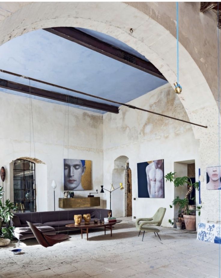 a living room filled with furniture and paintings on the walls