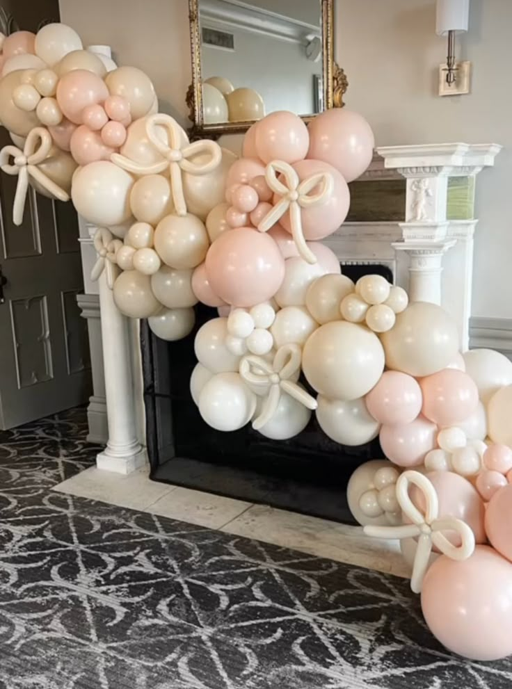 balloons and bows are arranged on the fireplace mantel