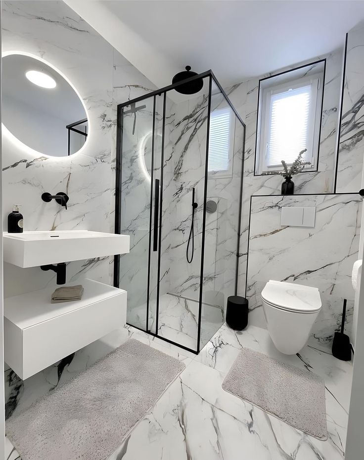 a white bathroom with marble walls and floors