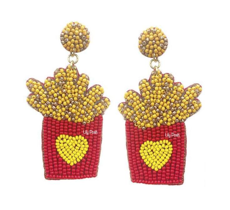 a pair of red and yellow beaded earrings with hearts on the front, sitting next to each other