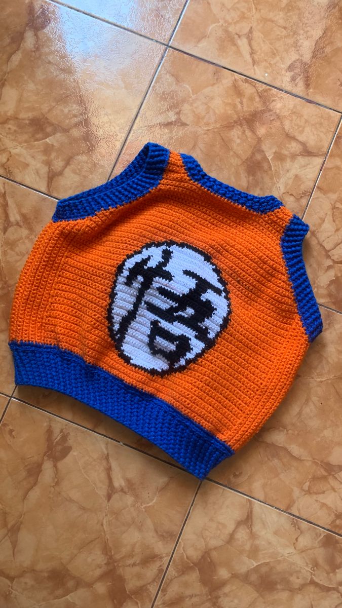 an orange and blue sweater sitting on top of a tile floor