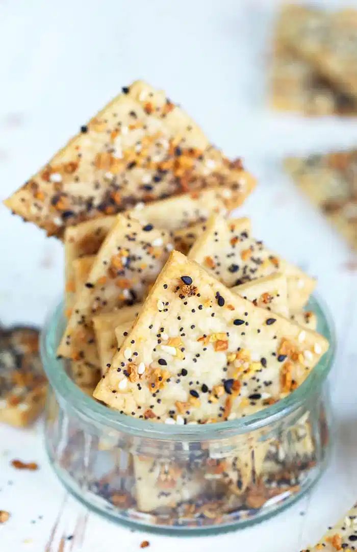 several pieces of crackers in a glass bowl on a white surface with sprinkles