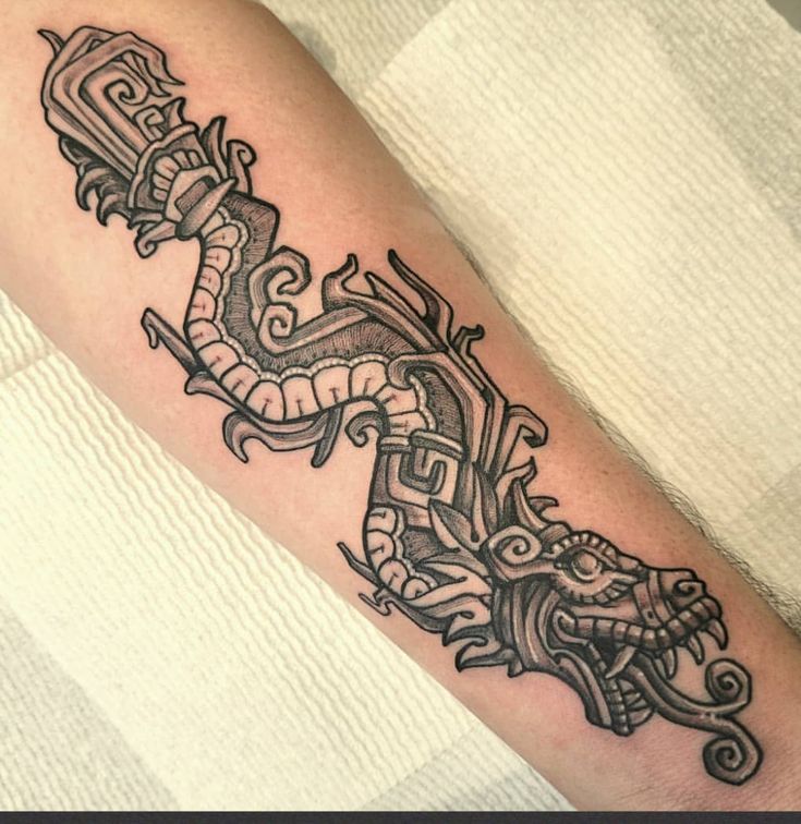 a black and white tattoo on the arm of a man with an ornate dragon design