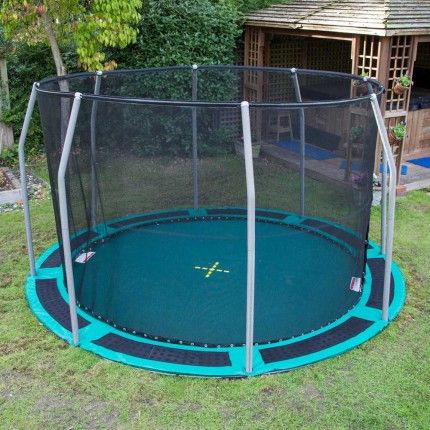 a trampoline in the backyard with a fence around it