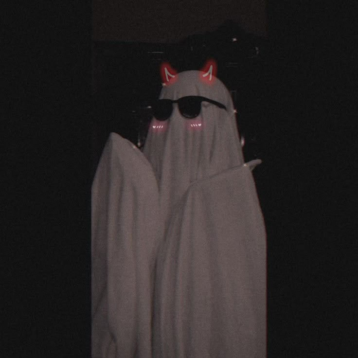 two white towels with red eyes and horns on them in front of a black background