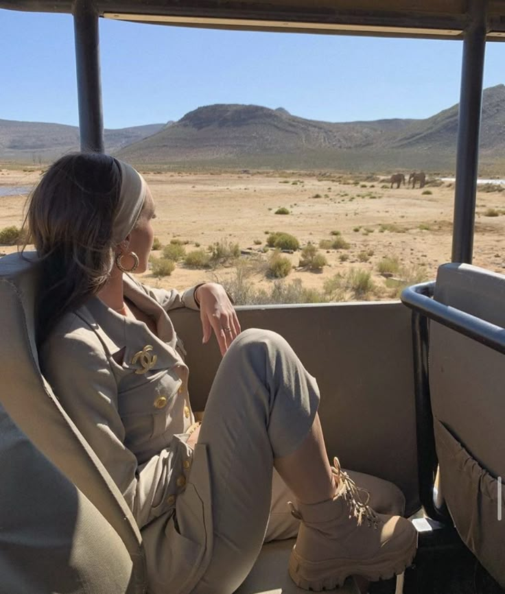 a woman sitting in the back of a safari vehicle