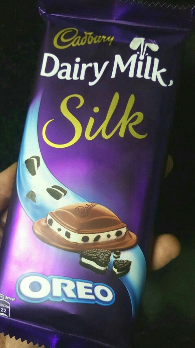 someone holding up a caddy milk silk bar with chocolate on it's wrapper