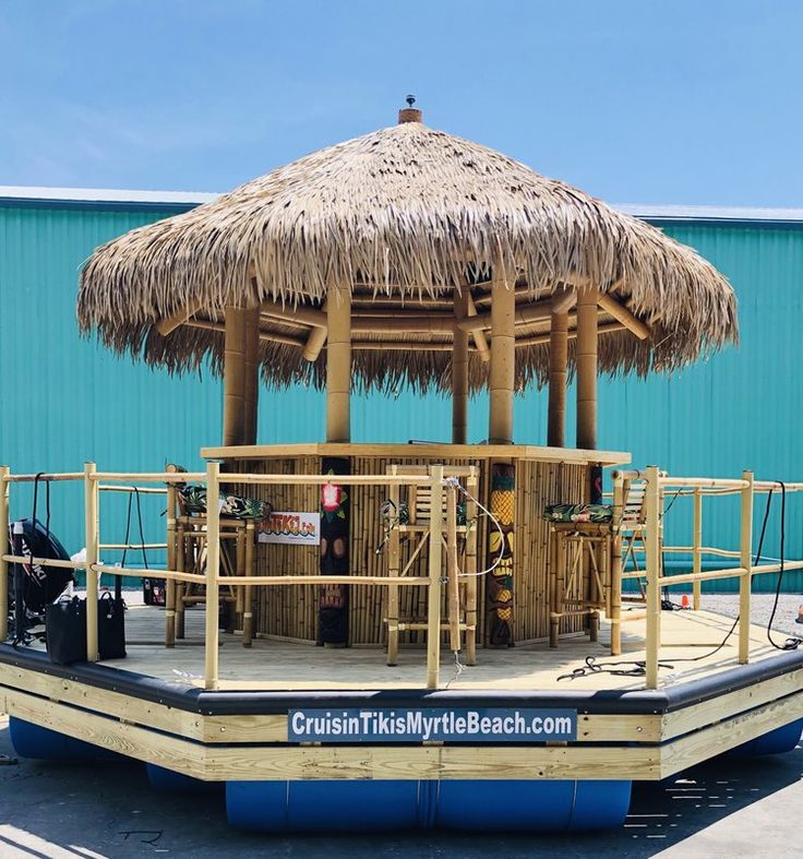 a boat that is sitting in the water with a straw umbrella on top of it