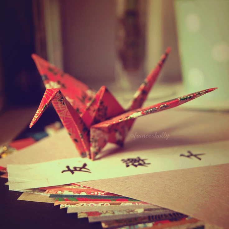 an origami bird sitting on top of paper