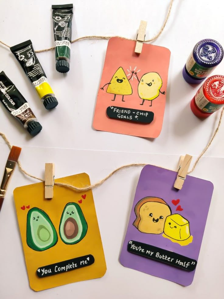 three small tags with cartoon characters on them hanging from clothes pegs and twine