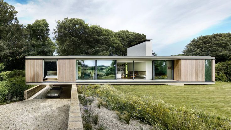 a modern house in the middle of a lush green field