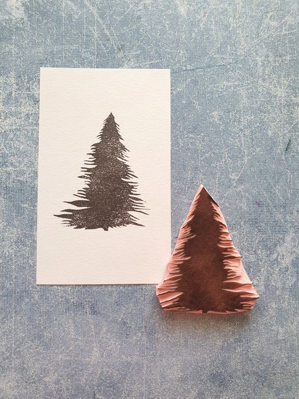 a piece of paper with a christmas tree drawn on it next to a brown ornament