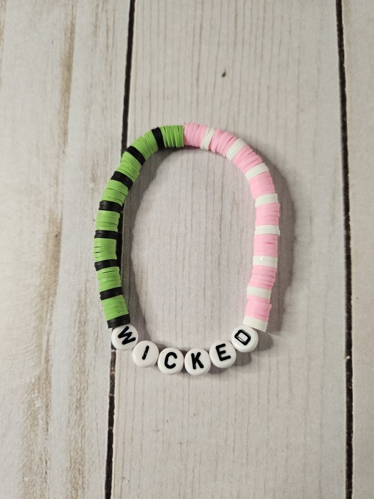 a pink and green bracelet with the word'kicked'written in white letters on it