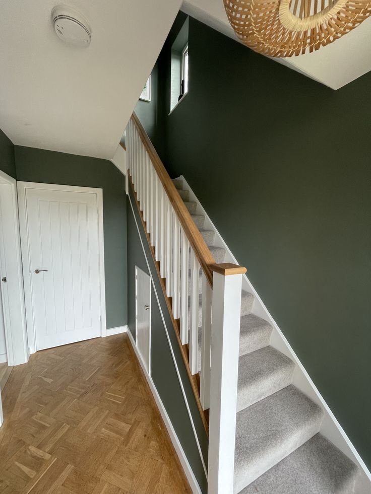 an empty room with green walls and stairs