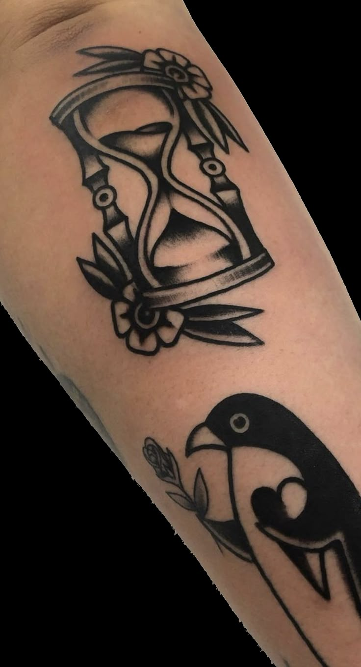 a black and white photo of a penguin with an hourglass tattoo on it's arm