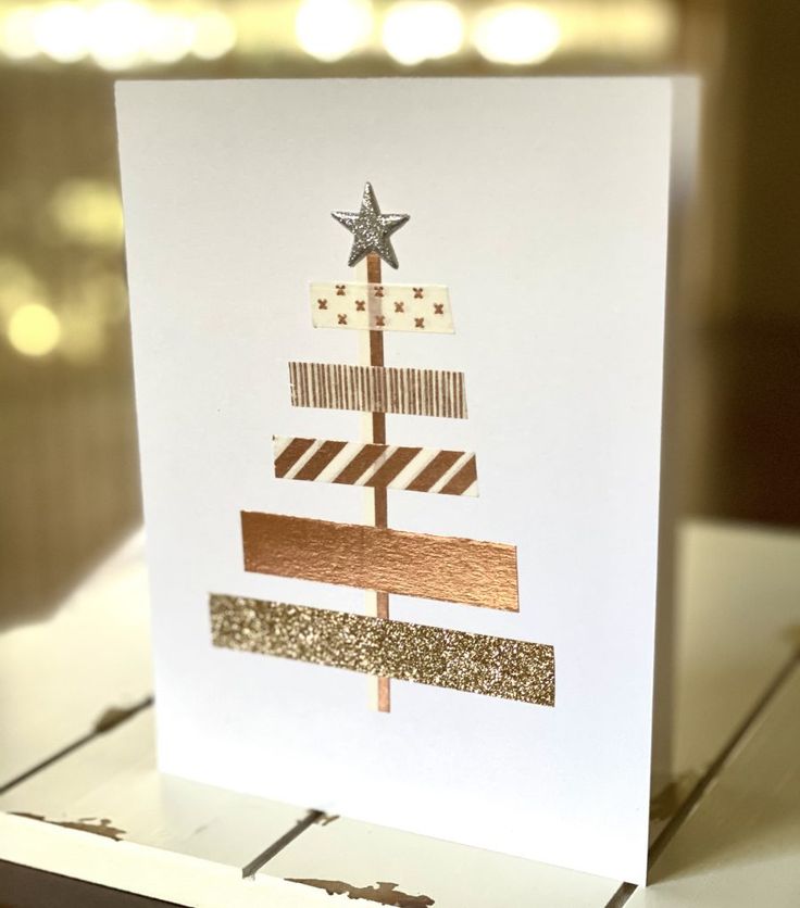 a card with a christmas tree made out of strips of wood and glitter on it