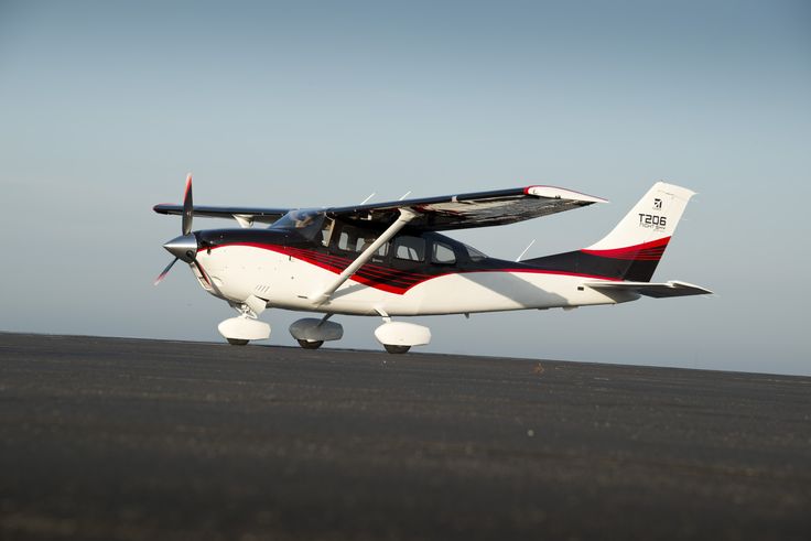 a small propeller plane sitting on top of an airport tarmac with it's landing gear down