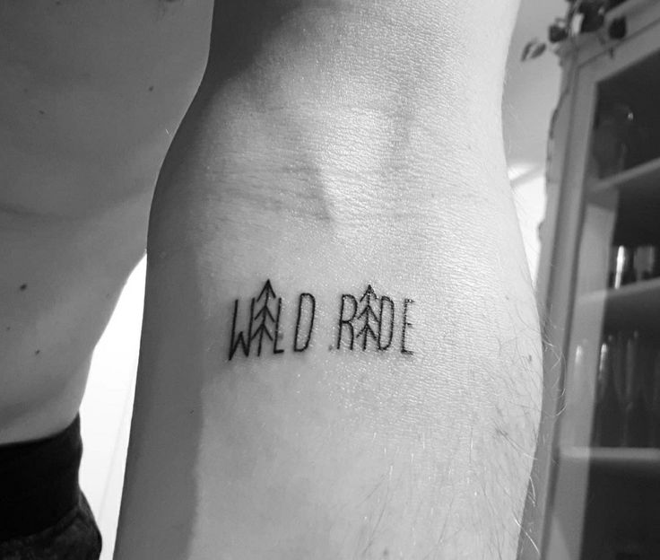 a man with a tattoo on his arm that says wild rade in black ink