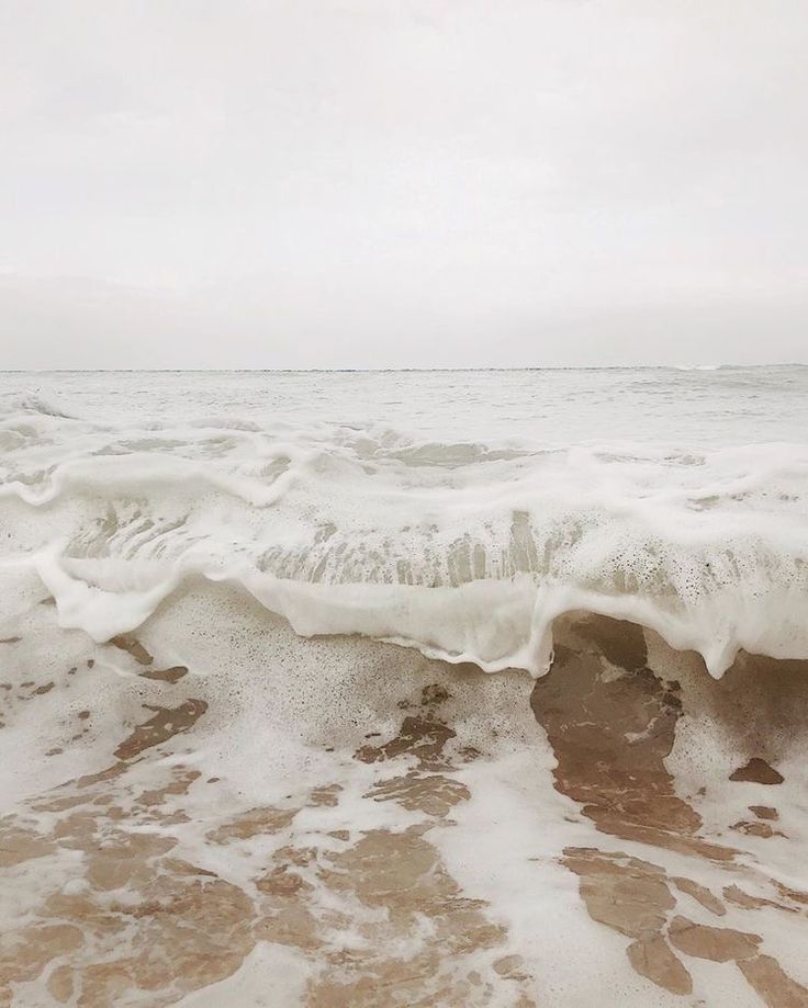 an ocean wave is breaking on the beach