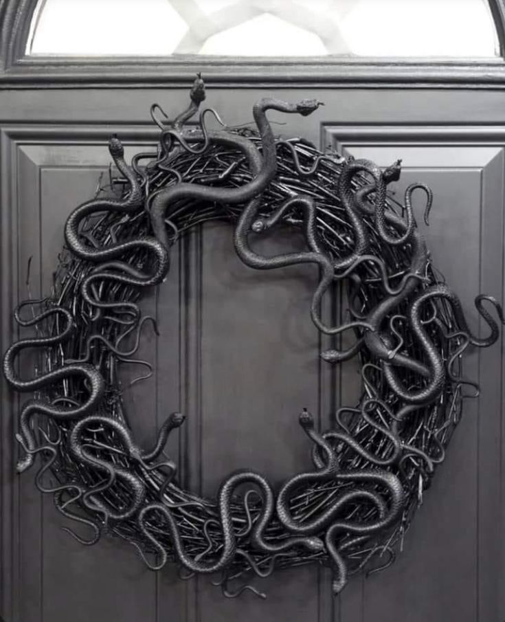 a wreath with black snakes hanging on the front door