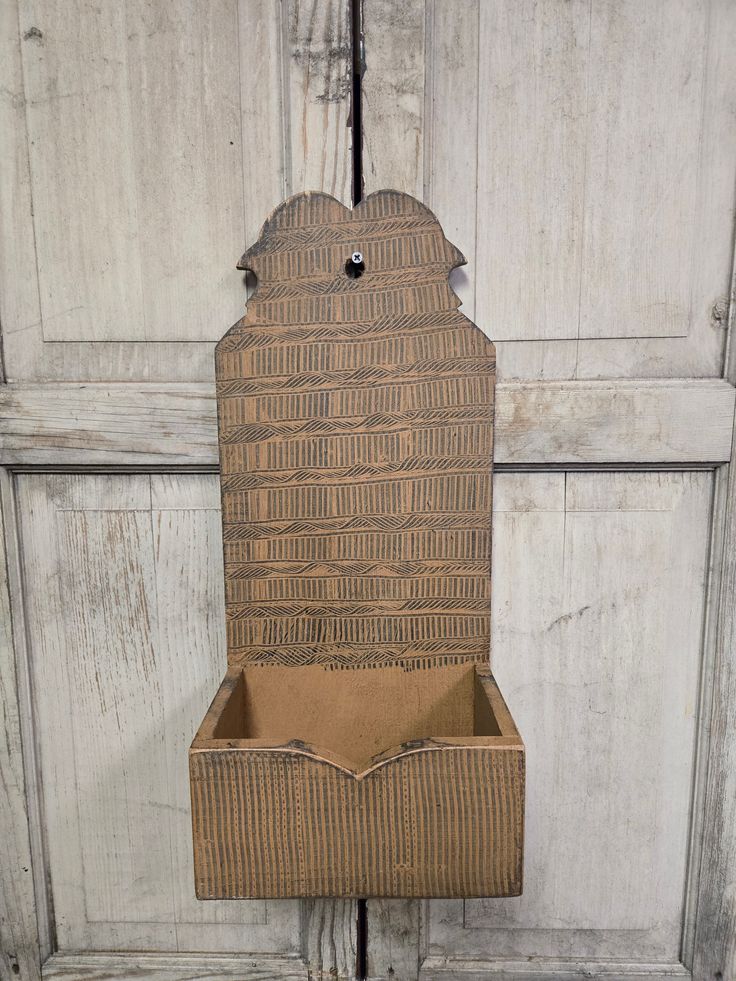 an open cardboard box sitting on top of a wooden door