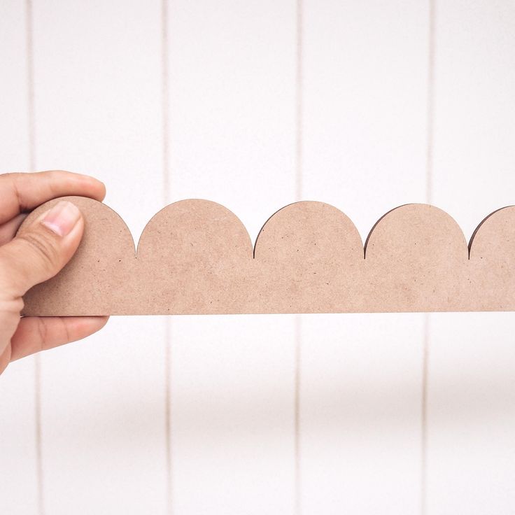 a person holding up a piece of cardboard that looks like a scallop pattern