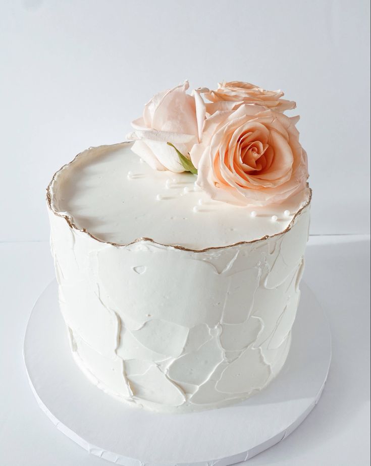 a white cake with frosting and flowers on top