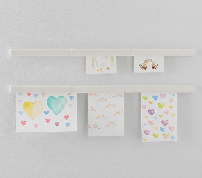 several cards hanging on a wall with hearts and rainbows