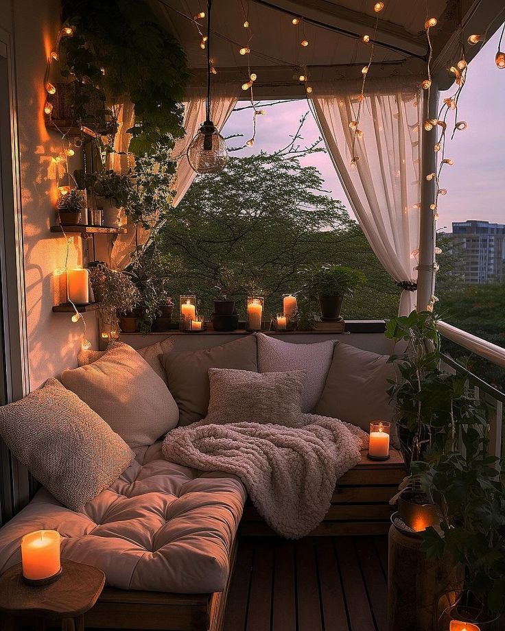 a couch sitting on top of a wooden floor next to a window filled with candles