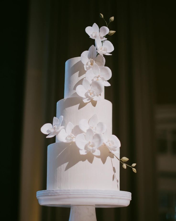 a white wedding cake with flowers on top