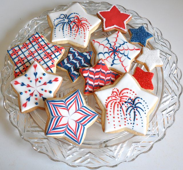 decorated cookies on a glass plate with red, white and blue decorations