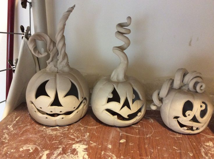 three carved pumpkins sitting on top of a wooden table