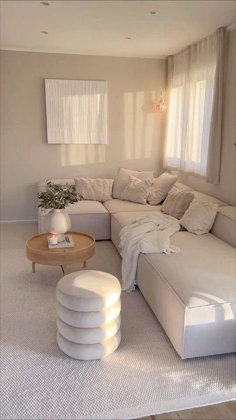 a living room filled with white furniture and lots of pillows on top of the couch